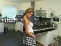 Jolie blonde en jupe qui se trémousse dans sa cuisine